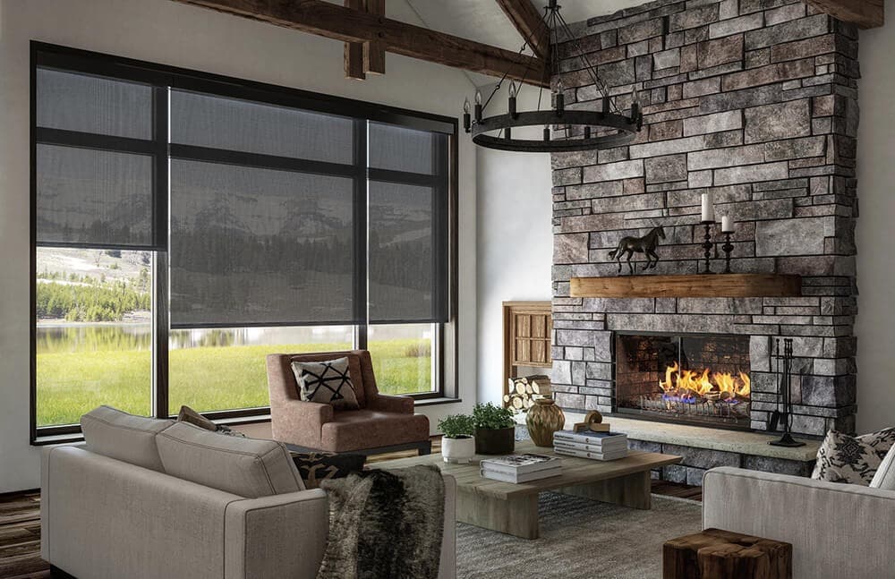 Custom solar roller shades on expansive living room windows with scenic mountain lake view in Calgary, Toronto, and Vancouver